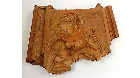 Mal voor een beeld van Maria met het kindje Jezus in haar armen.