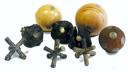 Houten ballen met puntige loden voorwerpen erin.